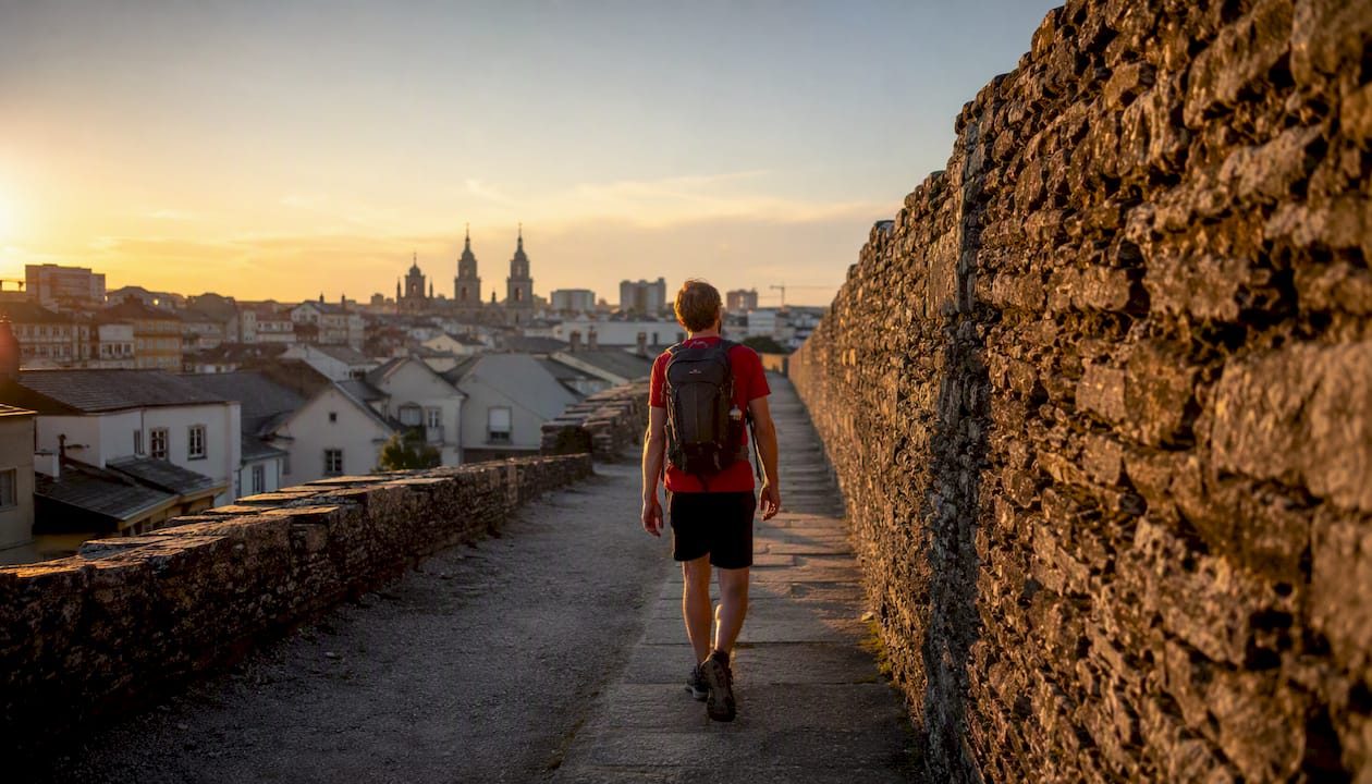Un visitante recorre el paseo superior de la muralla de Lugo