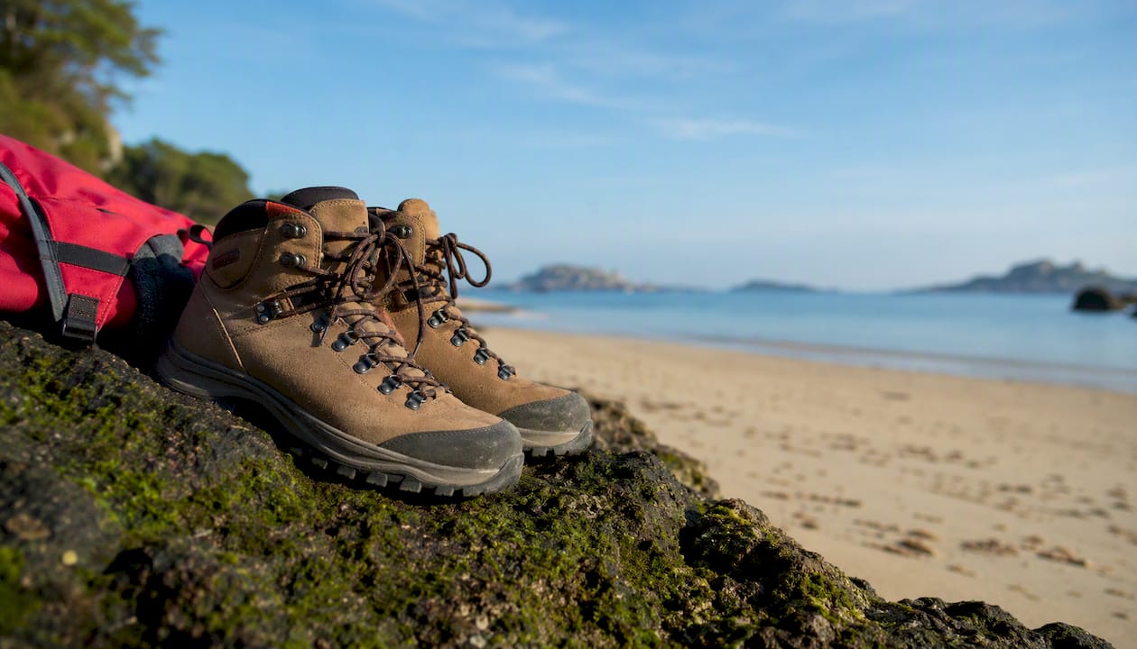 Botas sobre rocas cubiertas de algas, resbalando en la orilla del mar.