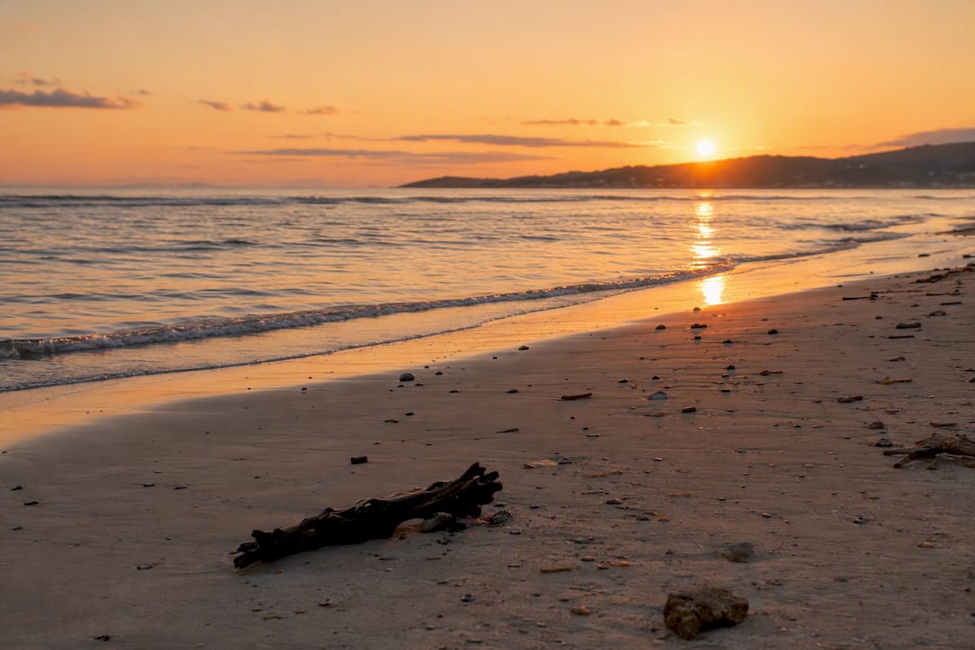 Atardecer en la playa de Langosteira, con el mar en calma y una atmósfera tranquila.