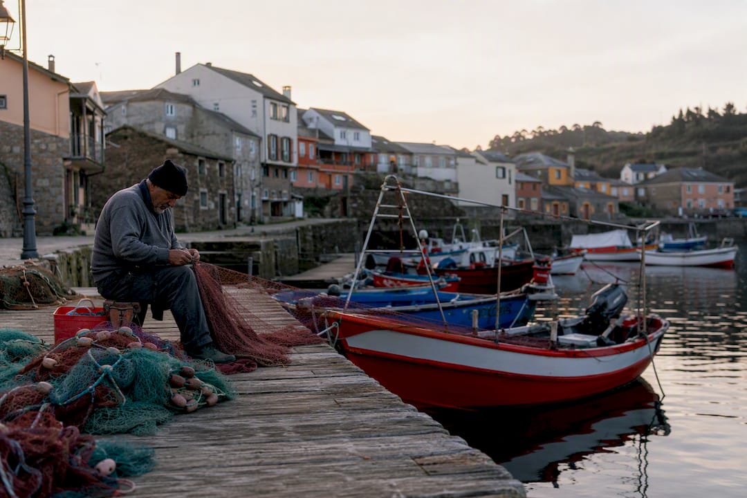 Barcos de pesca y redes en el pueblo de Rinlo