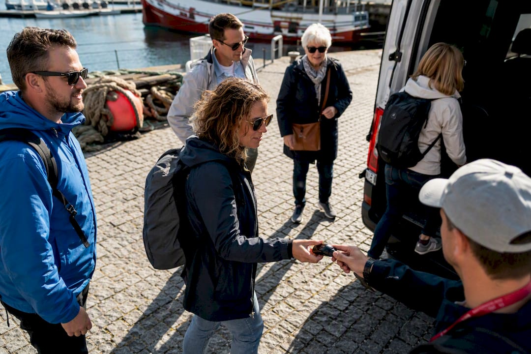 Turistas de crucero subiendo al minibús turístico en un puerto gallego
