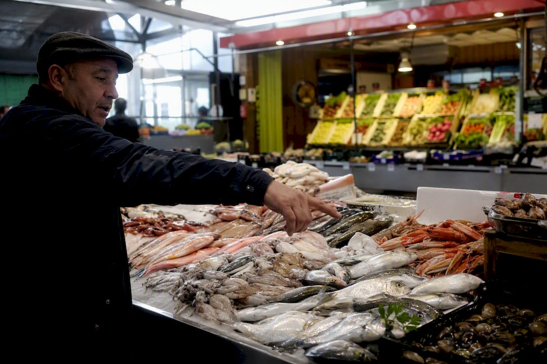 Guía local señalando pescado fresco en el mercado