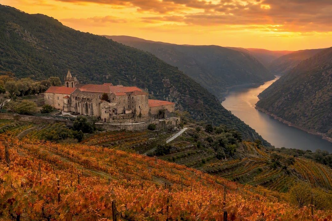 Monasterio rodeado de viñedos otoñales en la Ribeira Sacra
