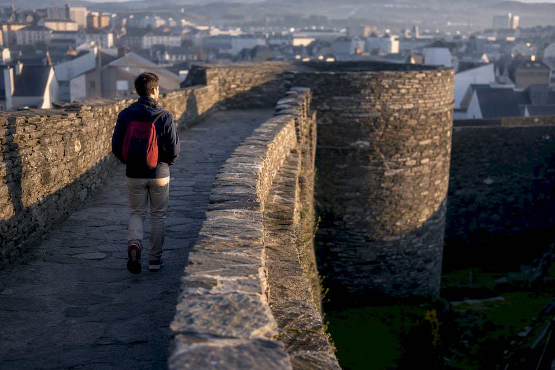 Persona caminando sobre la muralla de Lugo