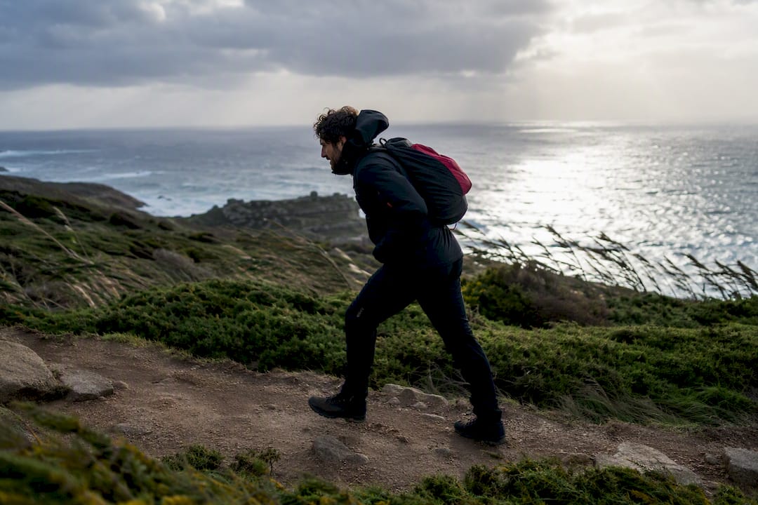 Peregrino caminando contra el viento del Atlántico
