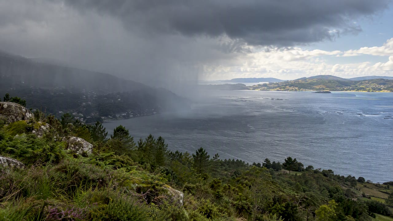 Cortina de lluvia cayendo sobre una ría con claros