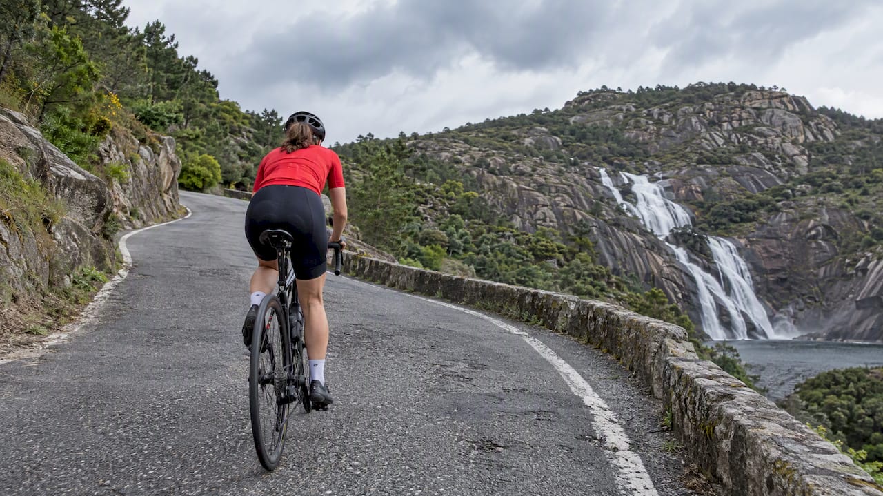 Ciclista ascendiendo hacia el mirador de Ézaro